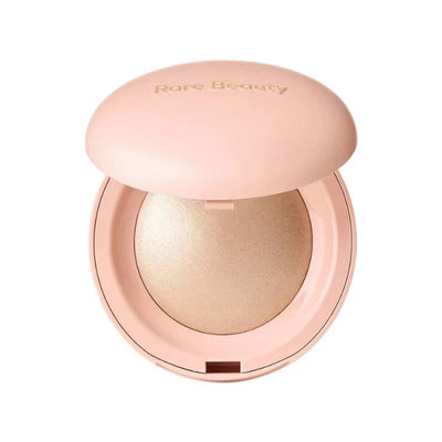 Powder highlighter by Rare Beauty with airy, pearl-infused texture in compact
