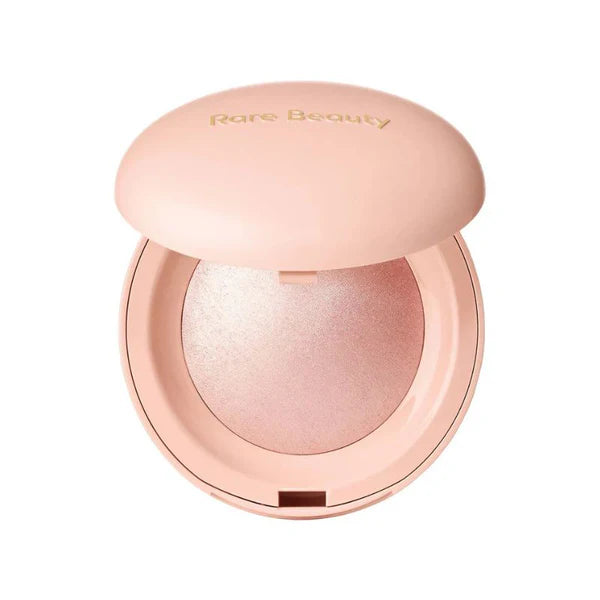 Powder highlighter by Rare Beauty with airy, pearl-infused texture in compact